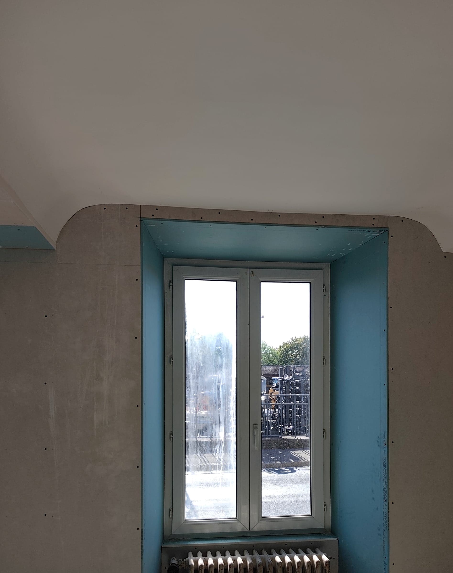 Fenêtre et radiateur dans un mur doublé, tableaux habillés de plaques