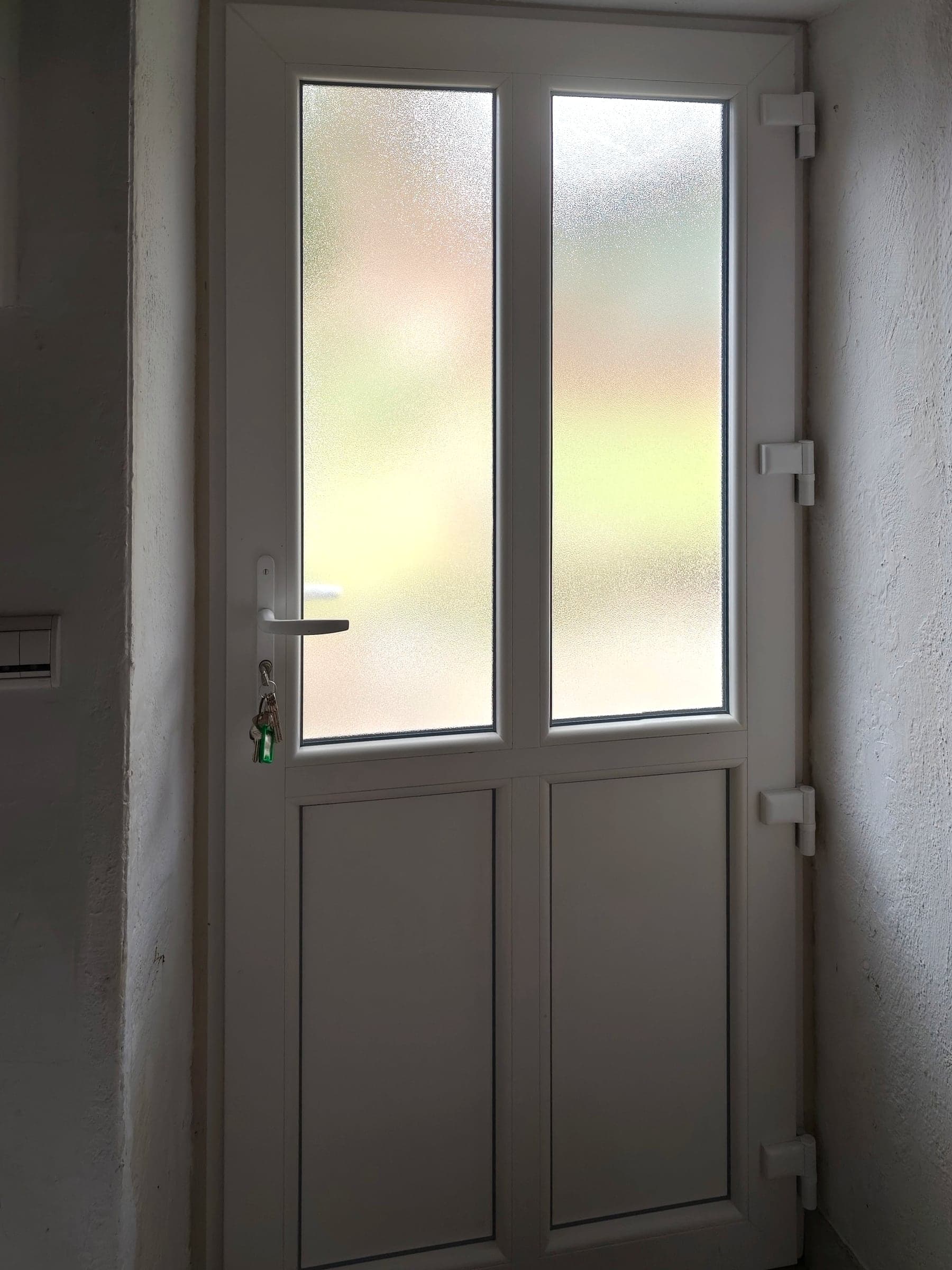 Porte de service en PVC blanc à vitrage dépoli, vue de l’intérieur